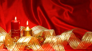 two lighted red and beige candles