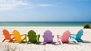 assorted colors wooden lounge chairs in the beach