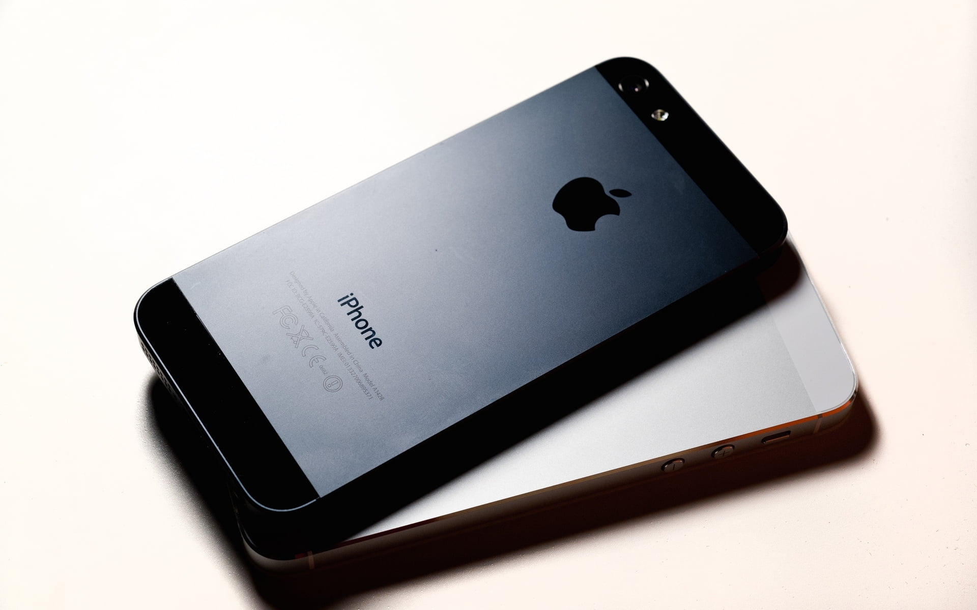 space gray and silver iPhone 5s on white surface