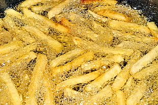 Potato fries dip in boiling oil