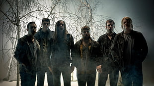 six men standing near bare trees