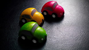 three yellow, red, and green coupe toys, artwork