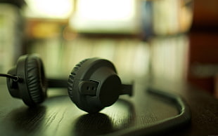 selective focus photo of headphones on wooden panel