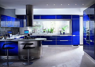 gray and blue kitchen area with two bar chairs