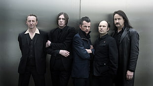 photograph of five men wearing black suits