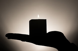 black and white photo of a person holding pillar candle