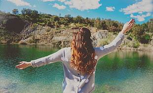 woman in gray long sleeve shirt facing lake HD wallpaper