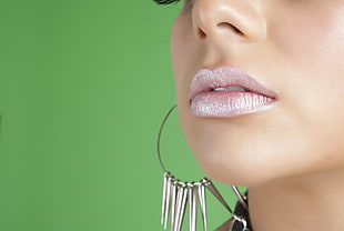 photo of woman wearing gray lipstick and silver hoop earring
