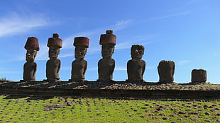 four brown wooden candle holders, eastern islands, landscape, Moai