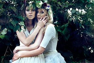 women wearing white dress behind green leaf plants