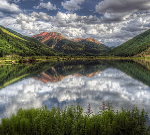landscape photo of body of water and mountain during day time