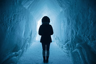 silhouette of woman standing inside cave of snow