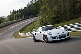 white Porsche sports coupe running on road