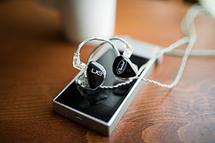 black UE earphones on top of grey mp3 player
