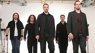 group of men wearing black formal coat behind white painted concrete wall
