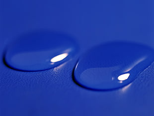 two drops of water on blue surface