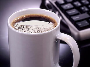 macro photography of white ceramic mug with full of black coffee