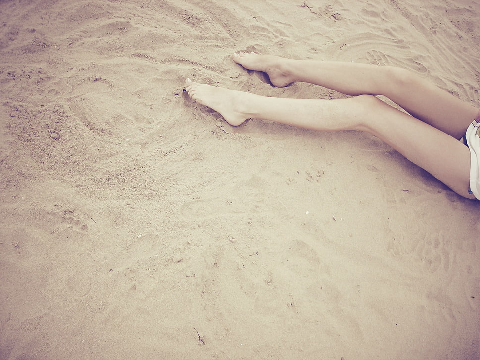 person's legs on brown sand high-angle photo HD wallpaper