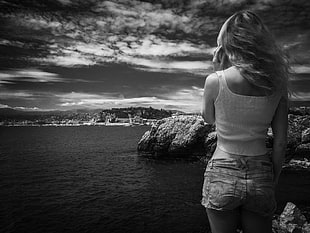 greyscale photo of woman at her back standing near body of water HD wallpaper