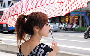 woman in black and grey sleeveless top holding pink and red umbrella