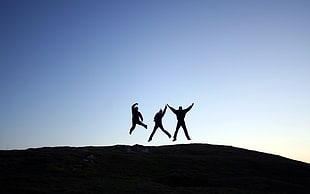 silhouette of three person jumping HD wallpaper
