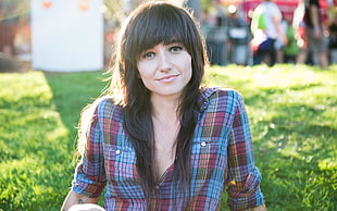 shallow focus on a person wearing a blue and pink flannel shirt during daytime