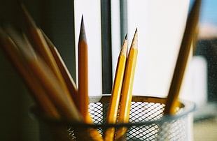 selective focus photography of pencils in basket