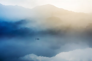 boat in the middle of foggy lake