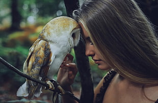 woman facing owl near tree