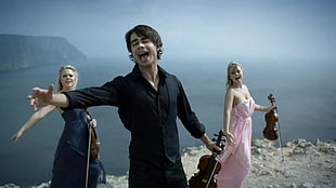 group of people holding violin on mountain top