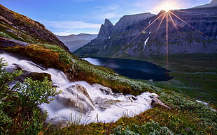 body of water with mountains under blue sky during daytime