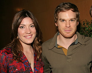 brown haired woman taking a picture with man in gray polo shirt