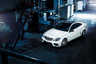 white Mercedes-Benz coupe parked inside building