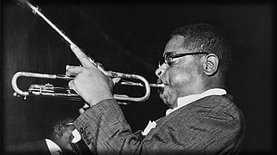 grayscale photo of a man playing wind instrument