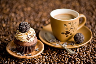 shallow focus photography of brown ceramic cup of coffee and saucer beside chocolate cupcake with vanilla cream and brown pastry HD wallpaper