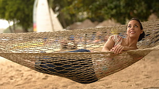 woman lying on brown hammock
