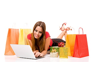woman using laptop white smiling with assorted shopping bags