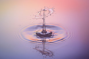 time lapse photo of water drop at the calm body of water
