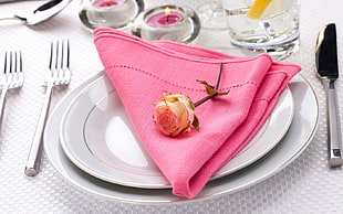 pink table napkin on top of white ceramic plates
