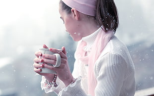 woman holding white ceramic mug