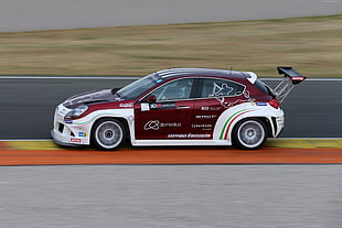 photography of red and white racing 5-door hatchback with black spoiler