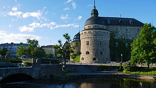 stone castle near river and bridge during daytime HD wallpaper