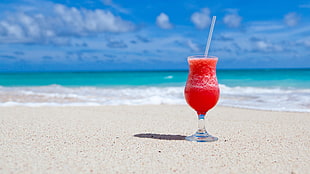 clear long-stem glass, beach, sand, cocktails, tropical