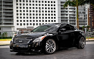 black Infiniti coupe parked near concrete building HD wallpaper