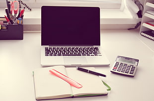 MacBook Pro near notebook and twist pen