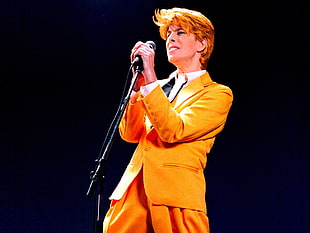 man in orange suit holding microphone