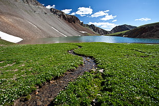 landscape photography of lake surrounded by high mountains under blue sky, cloud peak