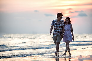 couple walking on sea shore HD wallpaper