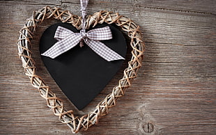 heart brown wreath with black ornament on wooden surface