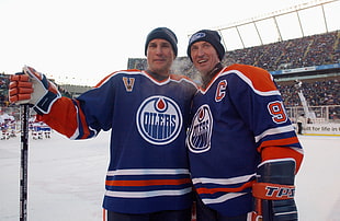 two Oilers hockey players standing on ice rink during daytime HD wallpaper
